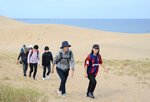 潮風を受けて鳥取砂丘を歩く参加者＝１４日、鳥取市福部町湯山の鳥取砂丘