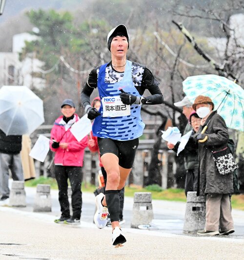 沿道の声援に応えて力走する岡本直己さん＝１６日、鳥取県庁近く