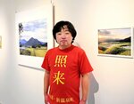 新温泉町の照来地区をＰＲするＴシャツを着て作品の前に立つ谷口さん