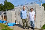 　再建中の自宅前に立つ太田滋さん夫妻＝６月、静岡県熱海市