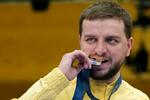 　パリ五輪の射撃男子ライフル３姿勢で獲得した銀メダルをかむウクライナのセルジー・クリシュ＝１日、シャトールー（ＡＰ＝共同）