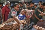 　エジプト側に移送するため、負傷者を救急車に運ぶ人ら＝１日、パレスチナ自治区ガザ南部ハンユニス（ゲッティ＝共同）