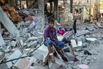 　パレスチナ自治区ガザ最南部ラファで破壊された家のがれきに座る人＝９日（ロイター＝共同）