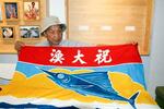　台湾北東部・宜蘭県蘇澳鎮で大漁旗について説明する頼栄興さん＝２０２４年５月１０日（共同）