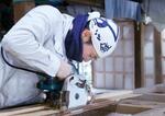 　木材を加工する韓国出身の塾生佃亮周さん＝４月、三重県志摩市