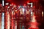 　台風１３号の影響による大雨で冠水した福島県いわき市内の道路を歩く人たち＝９日未明