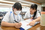 高校生ボランティア（右）に教わりながら宿題に取り組む中学生＝４日、倉吉体育文化会館