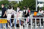 　北京の北朝鮮大使館が用意したとみられる車両から多くの荷物を携行して北京首都国際空港のターミナルに向かう女性ら＝２２日（共同）