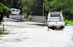 冠水した道路をゆっくりと走る車＝１３日、鳥取市内