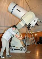 　大型天体望遠鏡の破損部分を説明する学芸員の宇佐美拓也さん＝８日午前、石川県能登町