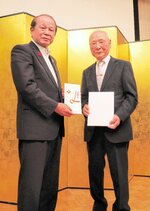 本紙ひろば面掲載分の図書カードを吉田町長（左）に贈る小河さん