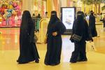 　伝統衣装「アバヤ」を身に着け、ショッピングモールで買い物をする女性＝２０１７年１１月、サウジアラビア・ジッダ（共同）