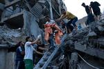 　イスラエルによる空爆で破壊された建物のがれきの中から救助される少女＝１０日、パレスチナ自治区ガザ（ＡＰ＝共同）