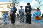 　奇祭「水祝儀」で冷水を浴びせられる大和田裕貴さん（左）ら３人の花婿＝８日午後、福島県いわき市