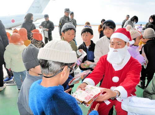 サンタクロース姿の隊員からプレゼントを受け取る園児＝１７日、境港市小篠津町の航空自衛隊美保基地