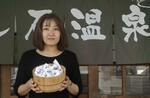 　廃棄シーツを加工したぬいぐるみ「湯ＺＡＭＥ」を持つ内山恵美さん＝２０２３年１１月、大分県別府市