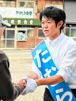 有権者と握手を交わす田村候補＝２１日、新温泉町のＪＲ浜坂駅前