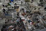 　イスラエル軍の攻撃で被害を受けた建物を調べる人々＝２９日、パレスチナ自治区ガザ南部ハンユニス（ロイター＝共同）