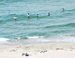 遊泳禁止となっている鳥取砂丘の海岸で遊泳する外国人のグループ＝６月１５日、鳥取砂丘（鳥取県自然共生課提供）