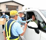 駐車場を出入りする車のドライバーに交通安全を呼びかける参加者ら＝１６日、鳥取市福部町湯山の鳥取砂丘駐車場
