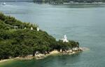 　広島県尾道市の因島にある大浜埼灯台（右）と通航信号塔＝２０２４年６月