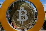 　ビットコインのマークを表示した像＝２０２４年１２月、エルサルバドル・イロパンゴ（ロイター＝共同）