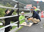 ガードパイプを丁寧に塗装する参加者＝２９日、八頭町大門