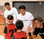 【ハイタッチ】ハイタッチで子どもたちを見送る（左から）長谷川選手、元日本代表の太田宏介さん、大久保さん