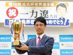 　記者会見で優勝カップを手に笑顔の一力遼三冠＝９日午後、東京都千代田区の日本棋院