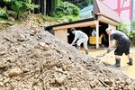 倉庫の壁を破壊して流れ込んだ裏山からの土砂。住民たちは土砂の撤去作業に追われた＝８月１６日、香美町村岡区入江