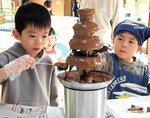 真剣な表情でチョコレートをかける子どもたち＝１１日、鳥取市浜坂のチュウブ鳥取砂丘こどもの国