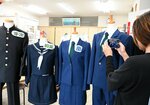 １０着ずつしか存在しない貴重な制服を写真に収めるコナンファン＝２１日、倉吉市鍛冶町１丁目のウォーキング・ギア・２００１