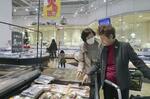 　スーパーで魚を選ぶ買い物客＝２０２３年１１月、兵庫県川西市