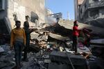 　ガザ地区南部ハンユニスで、イスラエルの攻撃によって破壊された建物を捜索する人々＝４日（ロイター＝共同）