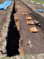 　縄文時代の集落跡「曽利遺跡」の発掘調査現場にあるトレンチ（大きな溝）の様子。土の色が変わったら住居跡らしい＝筆者提供