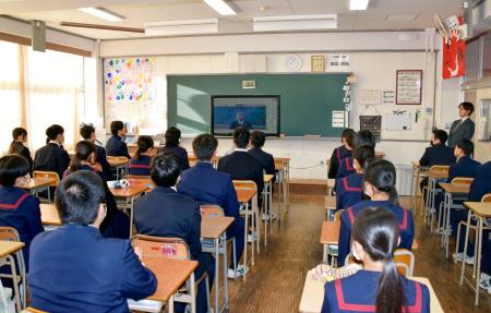 　北九州市小倉北区の中学校で開かれた始業式。インフルエンザ感染対策のため、生徒たちは教室に集まりオンラインで行われた＝８日午前