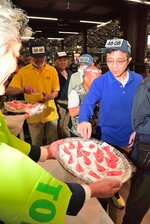 試食で振る舞われた鳥取県産スイカに手を伸ばす市場関係者ら＝１０日、東京・大田の大田市場