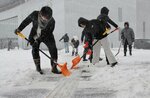 境港市民交流センター周辺を雪かきする市職員ら＝２２日午前８時２９分、同市上道町