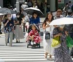 　日傘を差して名古屋駅前を歩く人たち＝２０日午前