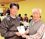 大阪鳥取県人会の安田会長（右）から寄付金を受け取る坂根主将＝大阪府東大阪市のホテルセイリュウ