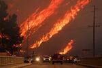 　ロサンゼルス北部の山火事で立ち上がる炎＝２２日、キャスティーク（ロイター＝共同）