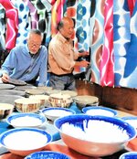 青色が鮮やかな陶器と色彩豊かなのれんが並んだ会場＝２１日、八頭町郡家のカフェ黒田