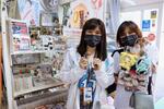 　岩手県軽米町の松橋商店に設けられた専門コーナーの前で、ポーズをとる「ハイキュー！！」ファンの女性たち＝４月