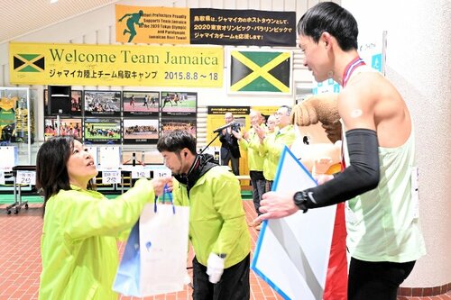 上位入賞者（右）に副賞を手渡す岸本常務＝１６日、鳥取市のヤマタスポーツパーク陸上競技場