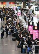 　羽田空港の出発ロビーで、航空券の払い戻しなどのため列を作る多くの人たち＝２日午後９時１４分