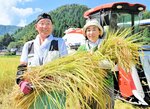 たわわに実ったブランド米「かにのほほえみ」の豊作を喜ぶ小谷さん親子＝５日、香美町香住区中野