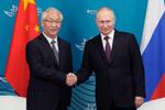 　ロシアのプーチン大統領（右）と握手する中国の張国清副首相＝１２日、ロシア・ウラジオストク（ＡＰ＝共同）
