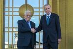 　２５日、パレスチナ自治政府のアッバス議長（左）と握手するトルコのエルドアン大統領＝アンカラ（ＡＰ＝共同）