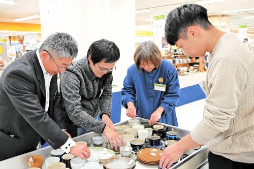 窯元らと販売台に作品を並べる椿窯の荒尾さん（左）