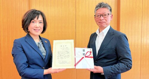 吉岡専務（左）から目録を受け取った株本会長